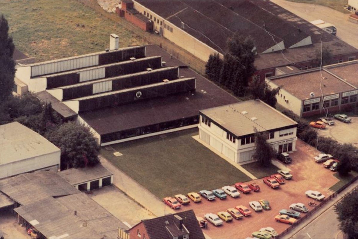 Luftaufnahme des Mangoldt-Firmengeländes in den 1970er-Jahren mit Verwaltungsgebäude, Produktionshallen und Parkplatz voller Fahrzeuge