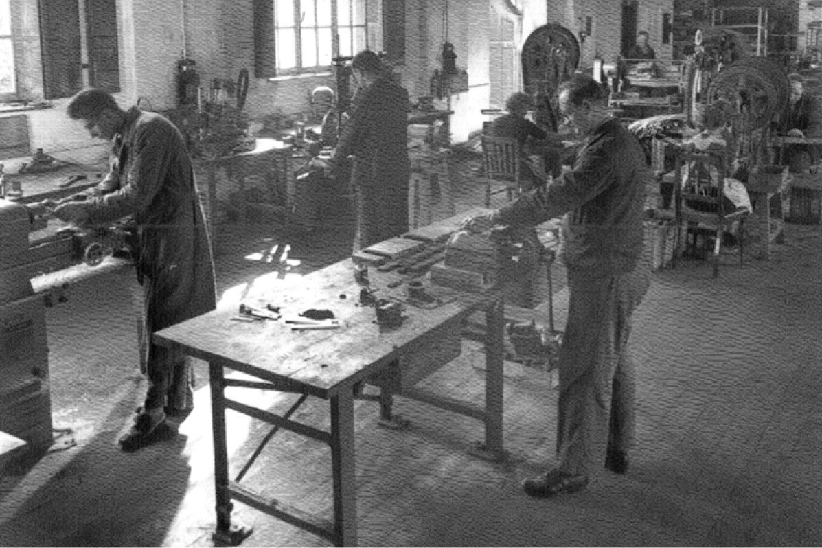 Historische Schwarz-Weiß-Aufnahme von Arbeitern in der Transformatorenfertigung in einer Werkhalle von Mangoldt